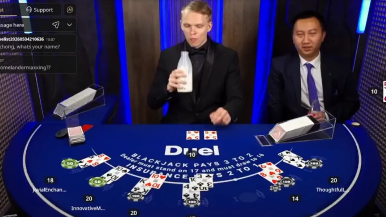 Duel owner Ossi Ketola behind the live blackjack table drinking milk from a bottle while seven seats play the hand out, blackjack pays 3 to 2 and insurance pays 2 to 1 printed on the felt