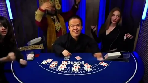 Dancers behind the dealer at the Duel blackjack table